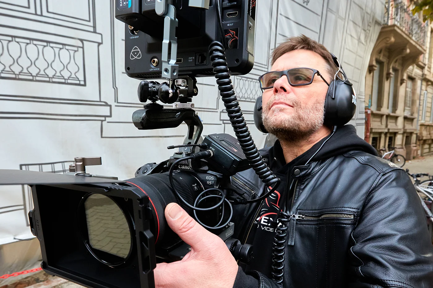 Vidéaste professionnel en tournage avec caméra cinéma Canon EOS R5 et moniteur Atomos pour une production audiovisuelle à Strasbourg.