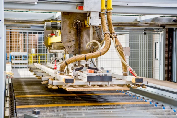 Système automatisé à ventouses assurant la manutention de panneaux sur une ligne de production dans l'usine Alsapan.