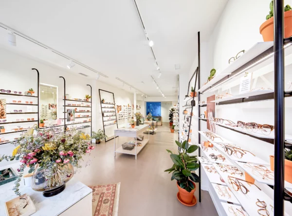 Vue d'ensemble d'une boutique d'optique moderne avec mobilier sur mesure et éclairage architectural.