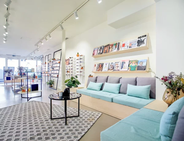 Coin accueil d'une boutique d'optique avec espace d'attente et présentation des collections.