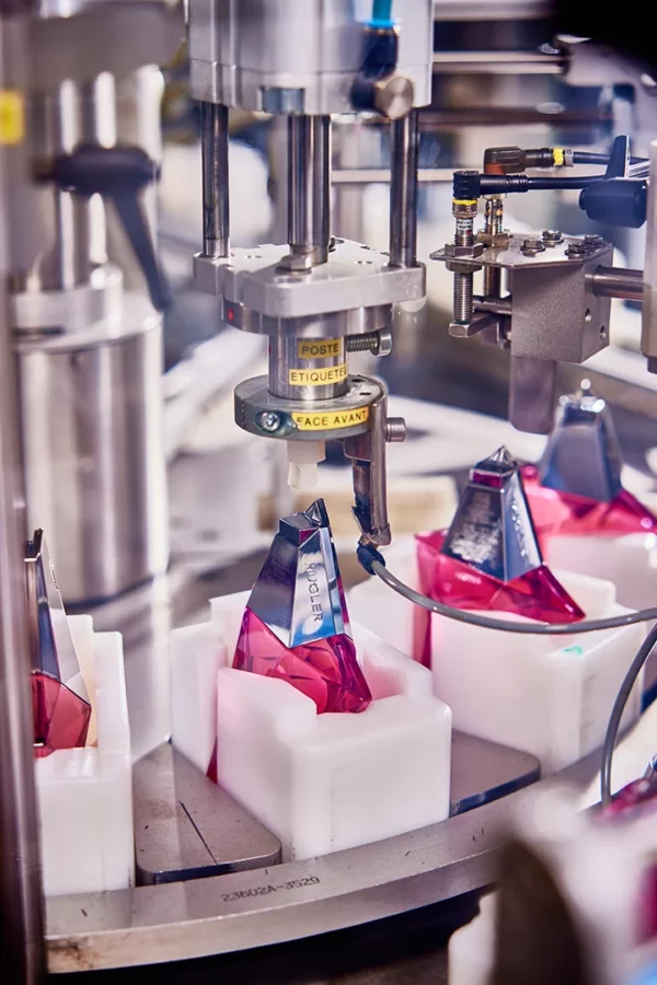 Machine d'étiquetage automatique appliquant les étiquettes sur des flacons de parfum dans l'usine Cosmeurop à Strasbourg.