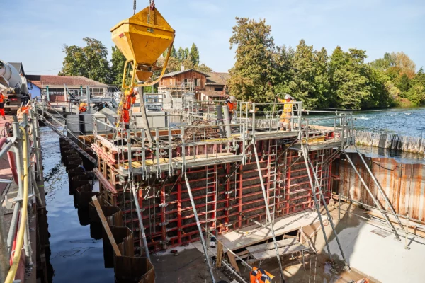Vue d'ensemble du coulage du béton sur un chantier VNF à Strasbourg avec bennes à béton, coffrages et équipes de génie civil dans le cadre d'un suivi de chantier.