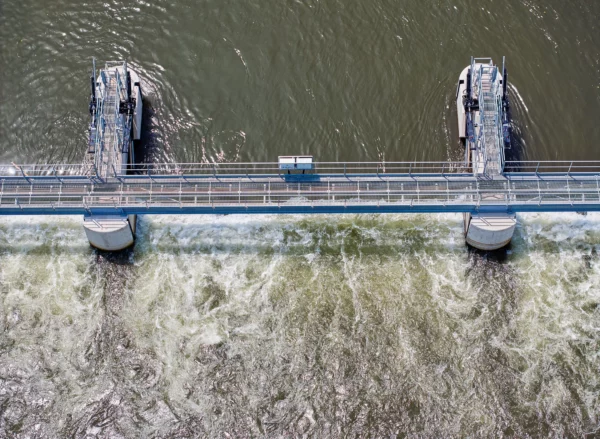 Vue verticale par drone du barrage de la Robertsau à Strasbourg montrant les ouvrages hydrauliques et l'écoulement de l'eau.
