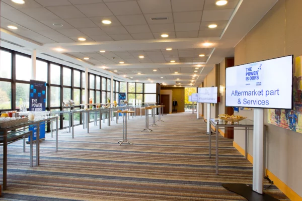 Espace de réception aménagé pour un séminaire d'entreprise à l'hôtel Hilton Strasbourg avec buffet et écrans de présentation