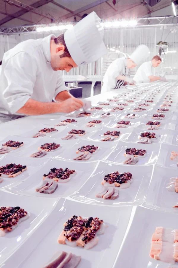 Brigade de cuisine dressant les assiettes lors des préparatifs du gala au Palais des Congrès de Strasbourg