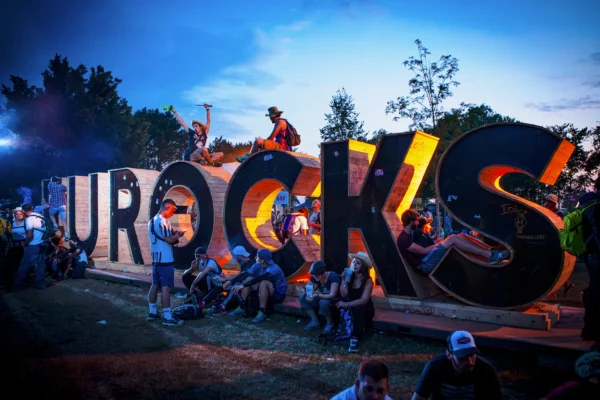 Entrée du festival des Eurockéennes de Belfort avec les grandes lettres « EUROCKS » et les festivaliers