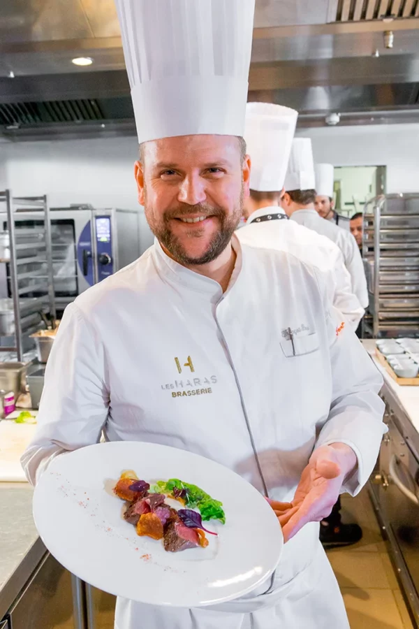 Le chef François Baur présente une assiette gastronomique dans les cuisines des Haras à Strasbourg lors d'un reportage photo événementiel.