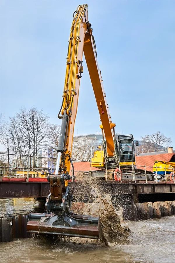Pelle hydraulique réalisant des travaux de terrassement sur un chantier VNF à Strasbourg dans le cadre d'un reportage photo de suivi de chantier.