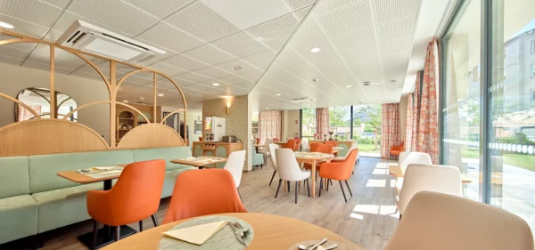 Salle de restaurant d'une résidence seniors avec décoration contemporaine.