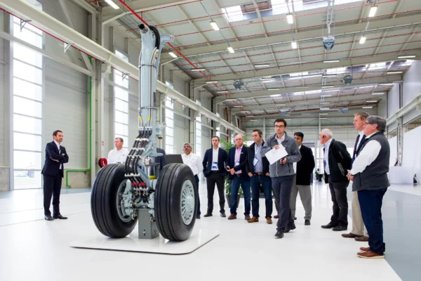 Visite d'entreprise dans l'usine Liebherr à Strasbourg devant un train d'atterrissage d'avion lors d'un reportage photo industriel.