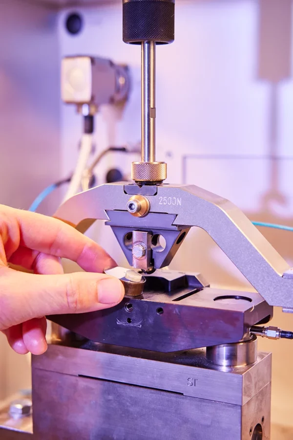 Technicien réalisant un essai mécanique sur un échantillon dans le laboratoire de contrôle qualité de Setral en Alsace.